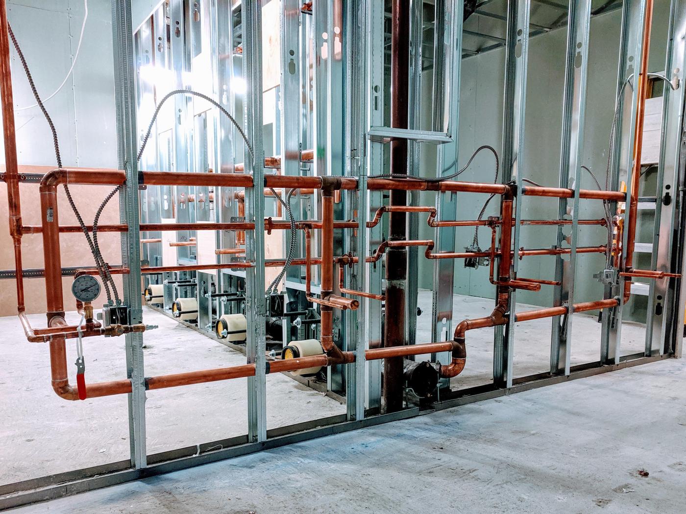 Copper supply manifold roughed into a steel-framed commercial wall